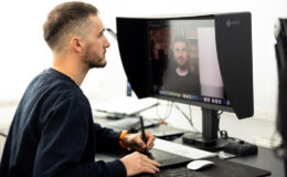 Fotograf upravuje fotografie na kalibrovanom monitore počas postprodukcie.