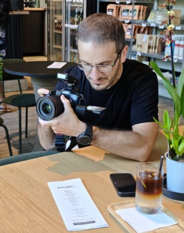 Fotograf pri práci s objektívom počas fotenia v teréne